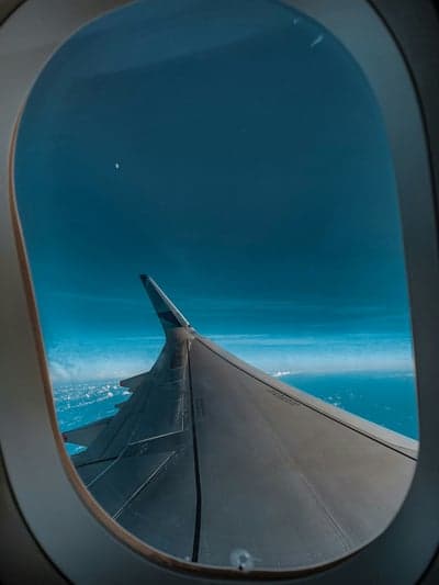 Airplane wing view from window over clouds and ocean