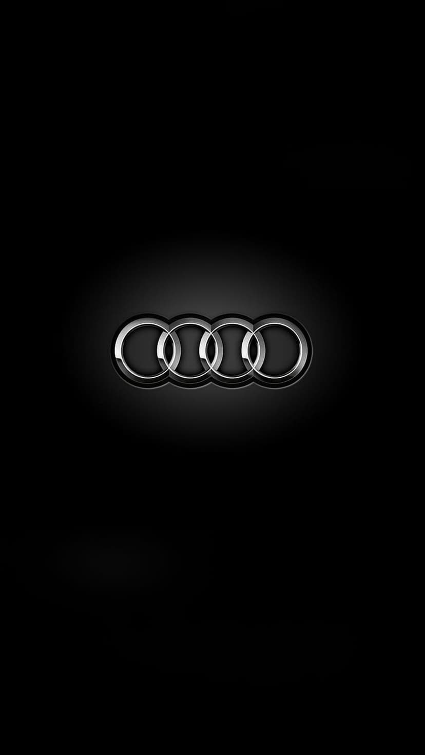 Four silver interlocking Audi rings with a polished chrome texture centered against a solid dark black background.