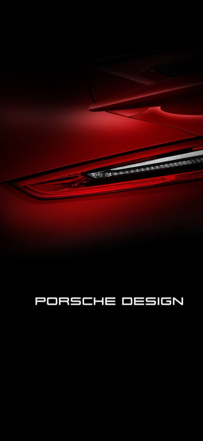 Red LED taillight of a Porsche luxury car glowing against a dark background with visible branding at the bottom.