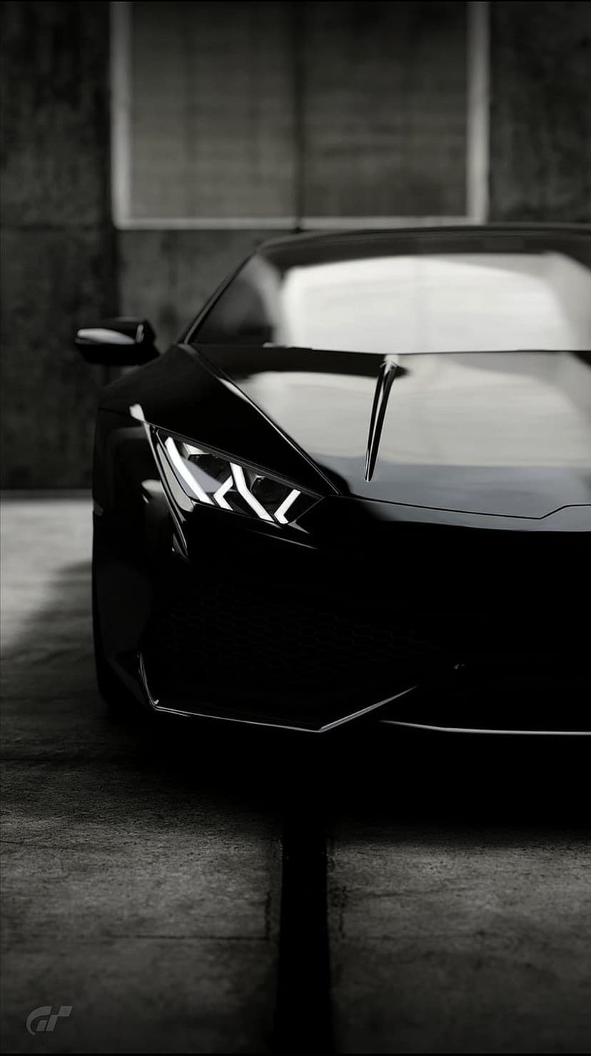 Lamborghini front headlights and hood detail with glowing LED accents against a textured concrete backdrop.
