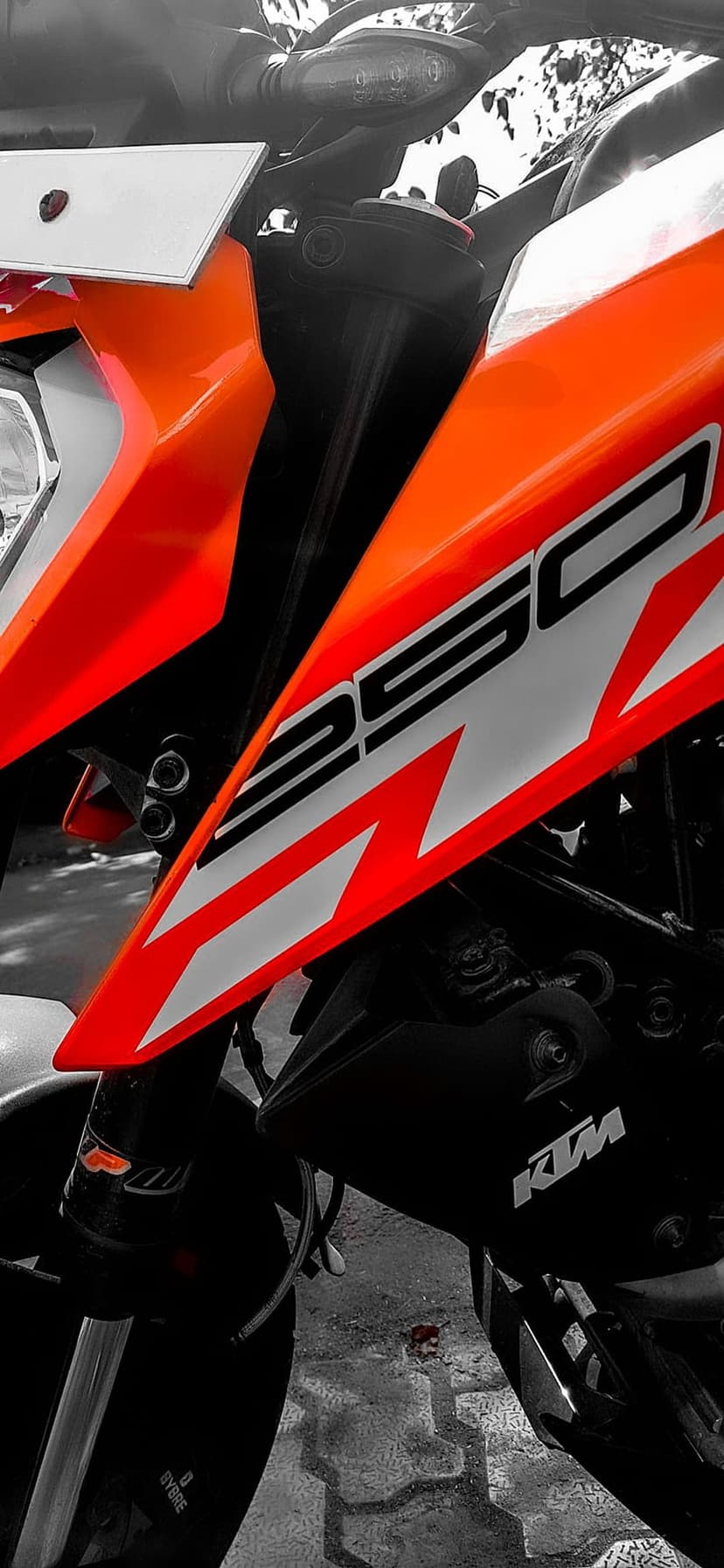 KTM 390 Duke motorcycle featuring orange fairings, WP front suspension, and LED headlight on a grayscale backdrop.