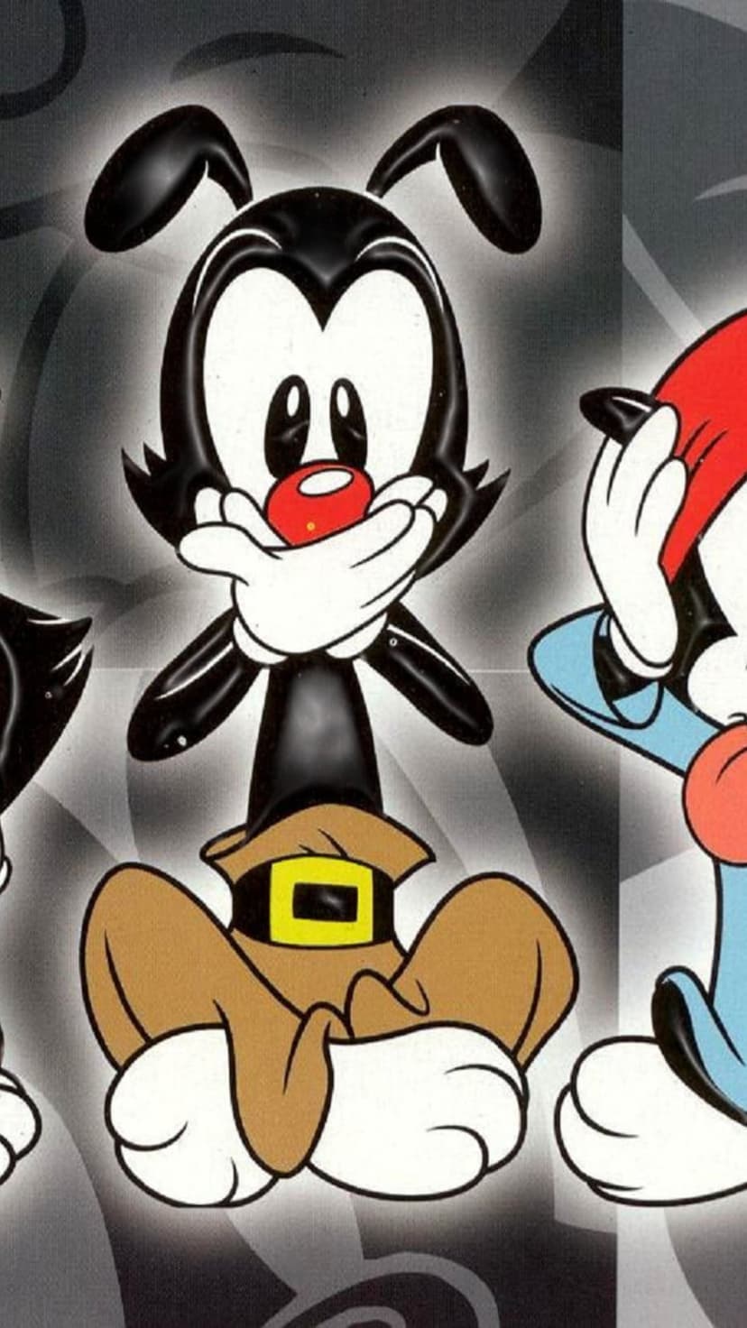 Yakko, Wakko, and Dot Warner cover their mouths against a gray abstract background in this vertical portrait.