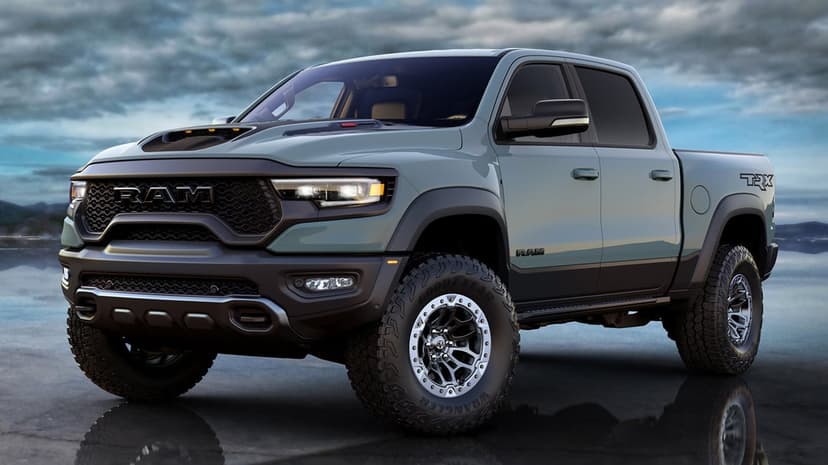 Anvil gray Ram 1500 TRX truck with off-road tires on a reflective ground under a moody, cloudy sky background.