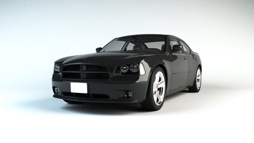 Black Dodge Charger front view with glowing LED headlights and a chrome grille against a solid white background.