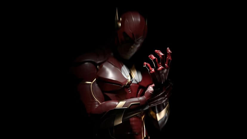 The Flash in red and gold armor adjusting his glove against a black background with dramatic low-key lighting.