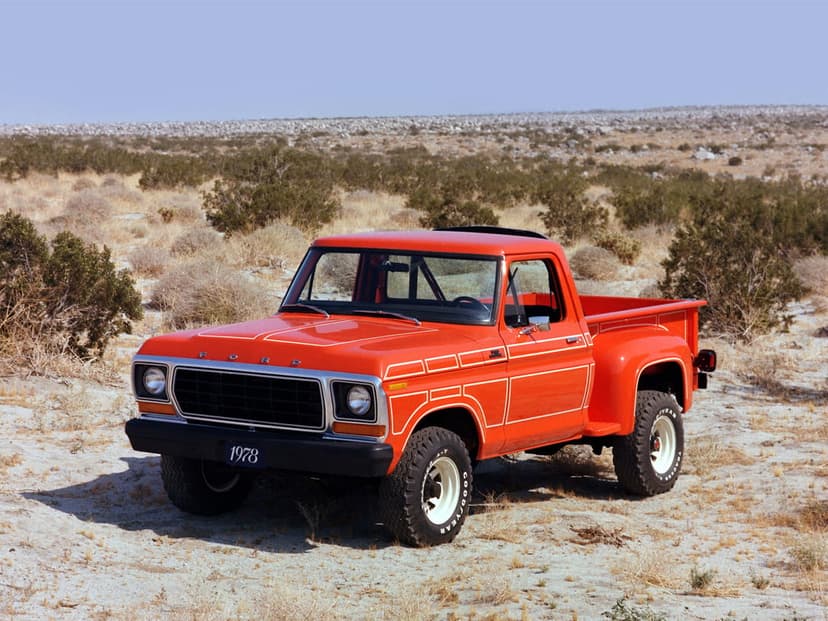 Red 1978 Ford F-150 flareside truck with white pinstripes parked in a sunny, arid desert landscape.