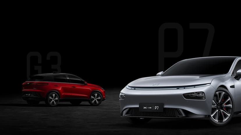 Silver electric sedan and red SUV in a dark studio with professional lighting and minimalist black background.