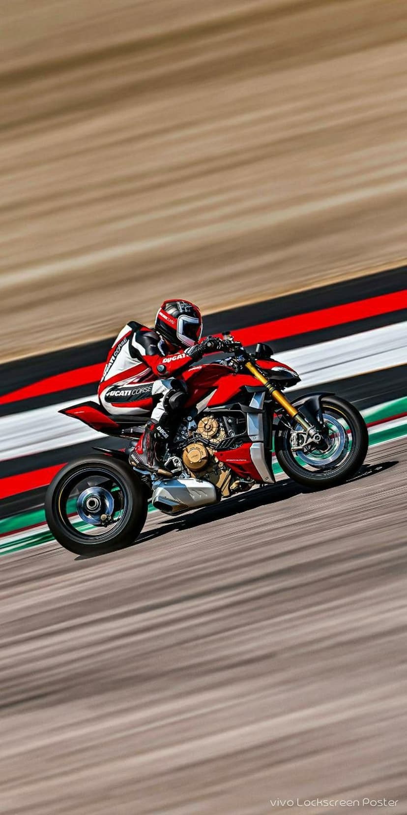 Ducati racer in red gear leans a sportbike into a sharp turn on a blurred asphalt track with brown and white stripes.