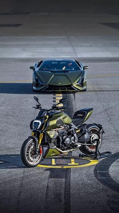 Green Lamborghini and Ducati motorcycle on asphalt