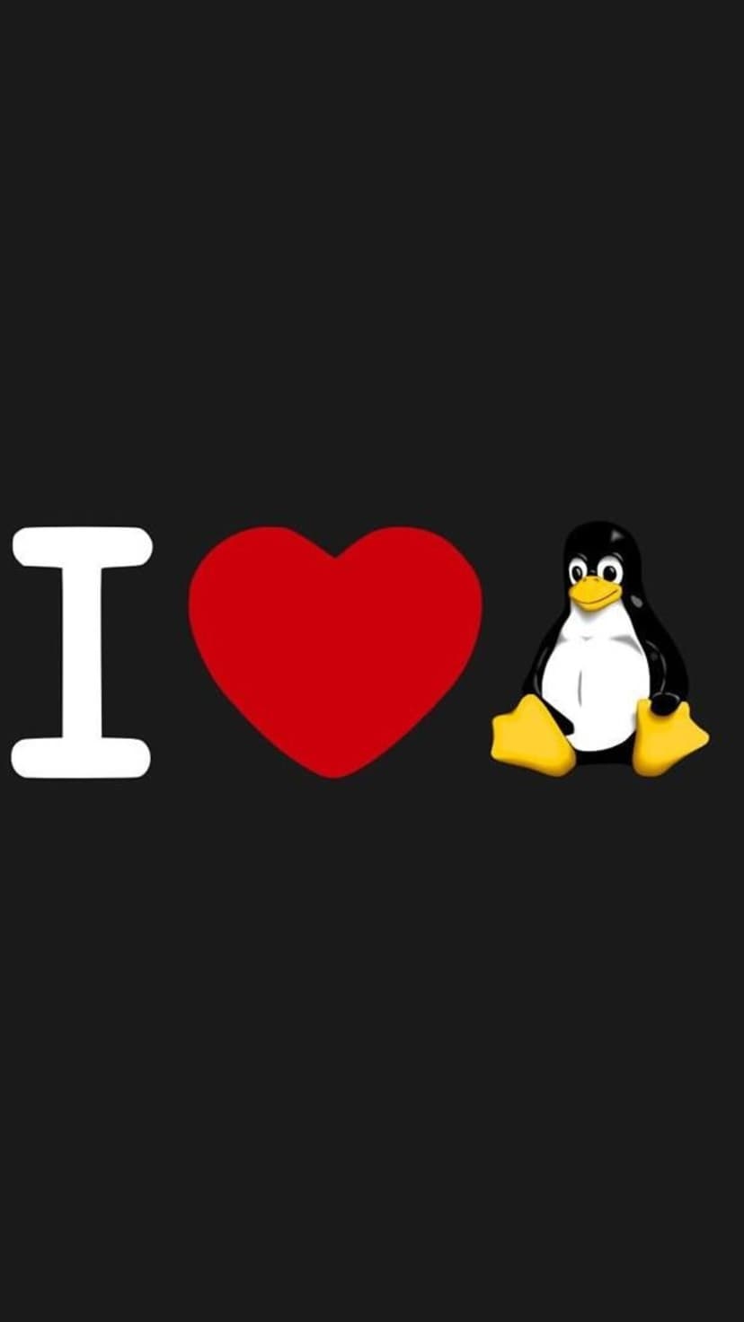 Tux the Linux penguin mascot sits next to a vibrant red heart and a white letter I on a solid black background.