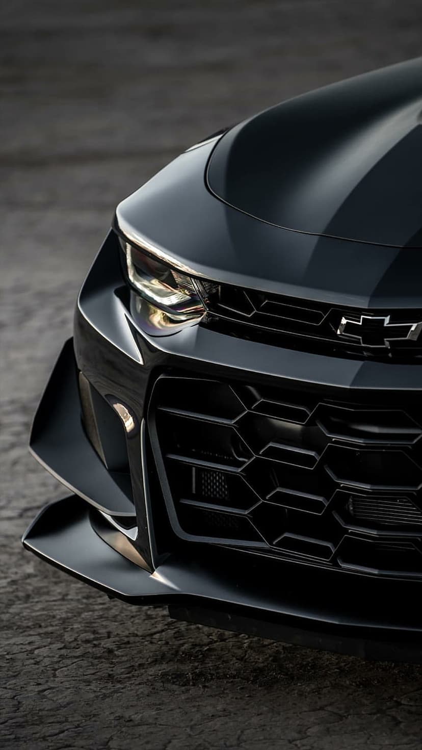 Black Chevrolet Camaro front end featuring LED headlights, a honeycomb grille, and a low-profile front splitter.