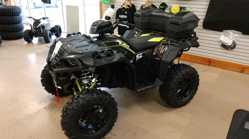 Black Polaris Sportsman XP 1000 S ATV featuring lime green accents and large off-road tires in a showroom.