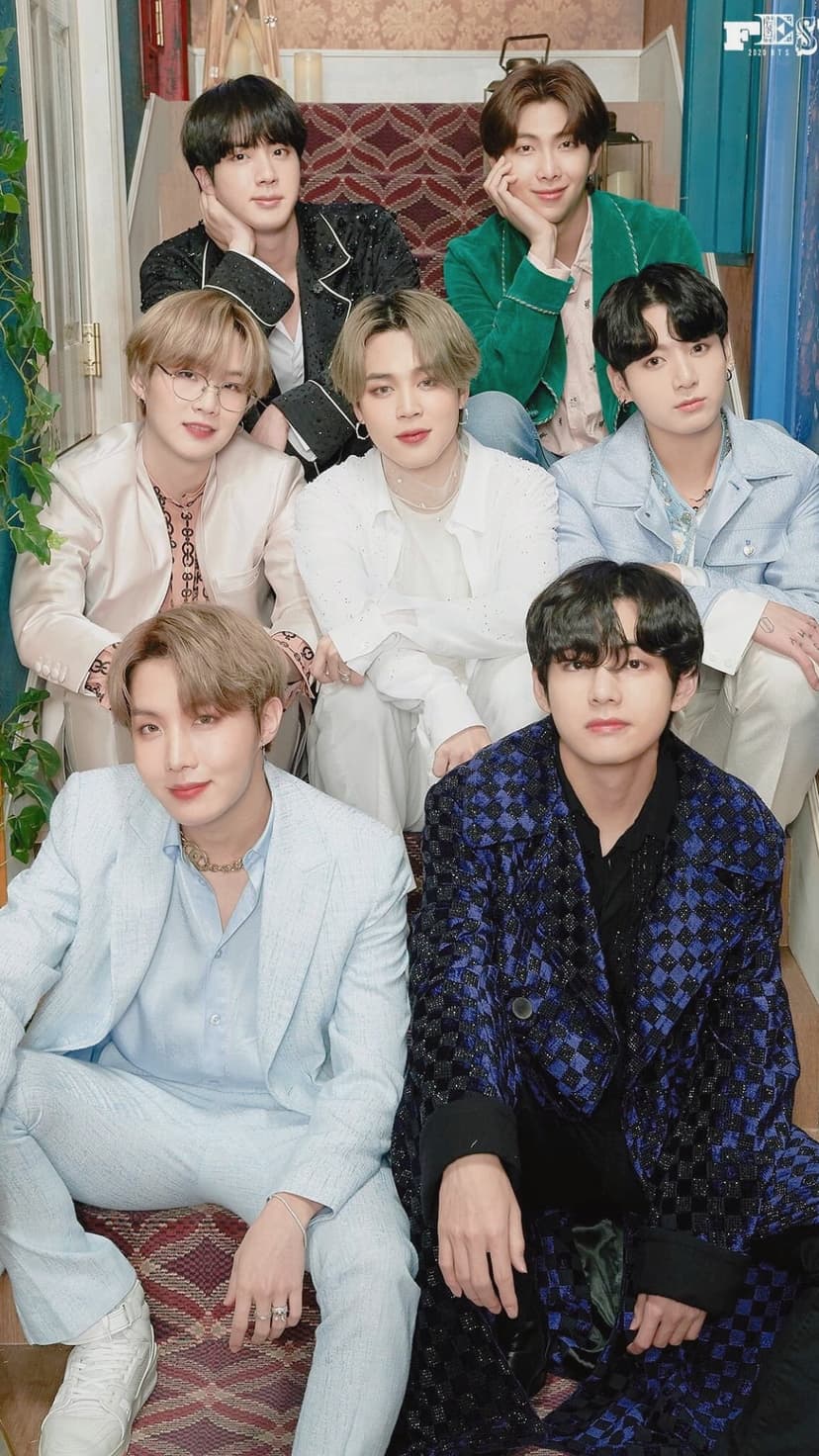 BTS members RM, Jin, Suga, J-Hope, Jimin, V, and Jungkook pose on stairs in pastel and patterned fashion.