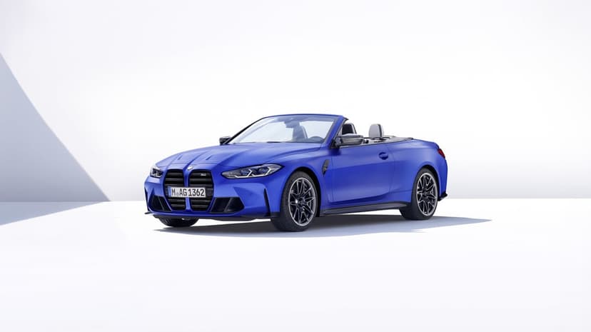 Blue BMW M4 Competition Convertible with top down in a bright white studio under soft directional lighting.