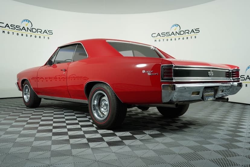 Red 1967 Chevrolet Chevelle SS 396 muscle car with chrome bumpers and rally wheels on a checkered floor.