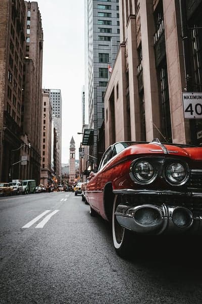Retro Red Cadillac Cruises Through City Streets