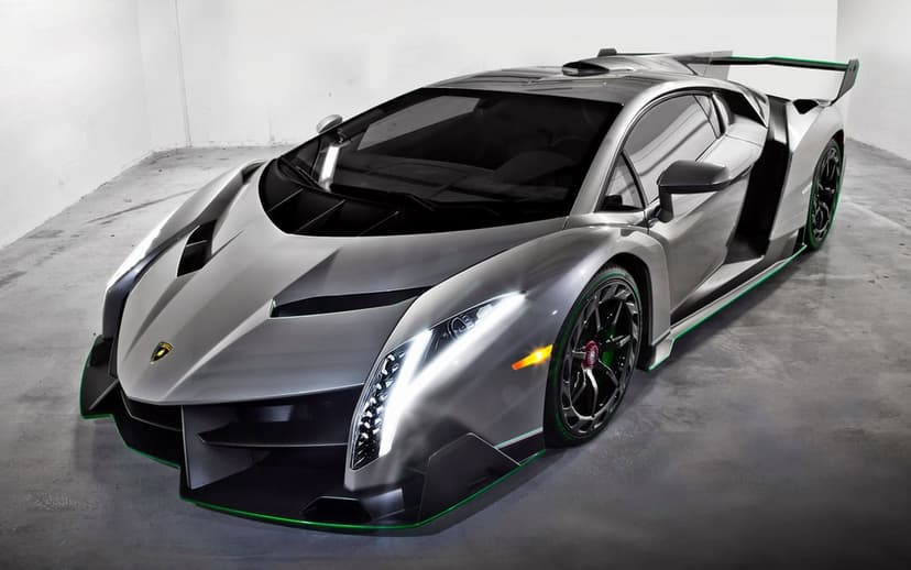 Silver Lamborghini Veneno with neon green trim and glowing headlights on a grey concrete floor in a studio setting.