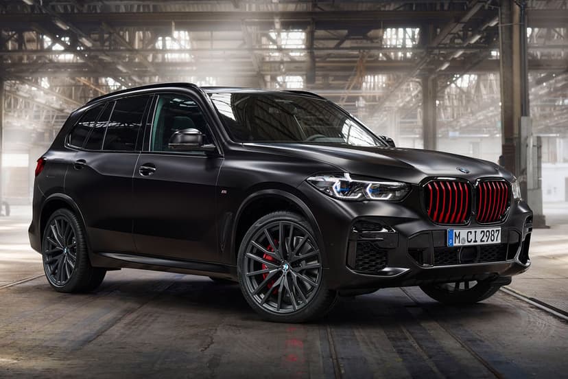 BMW X5 Black Vermilion Edition in a warehouse with red grille slats, matte paint, and dramatic lighting.