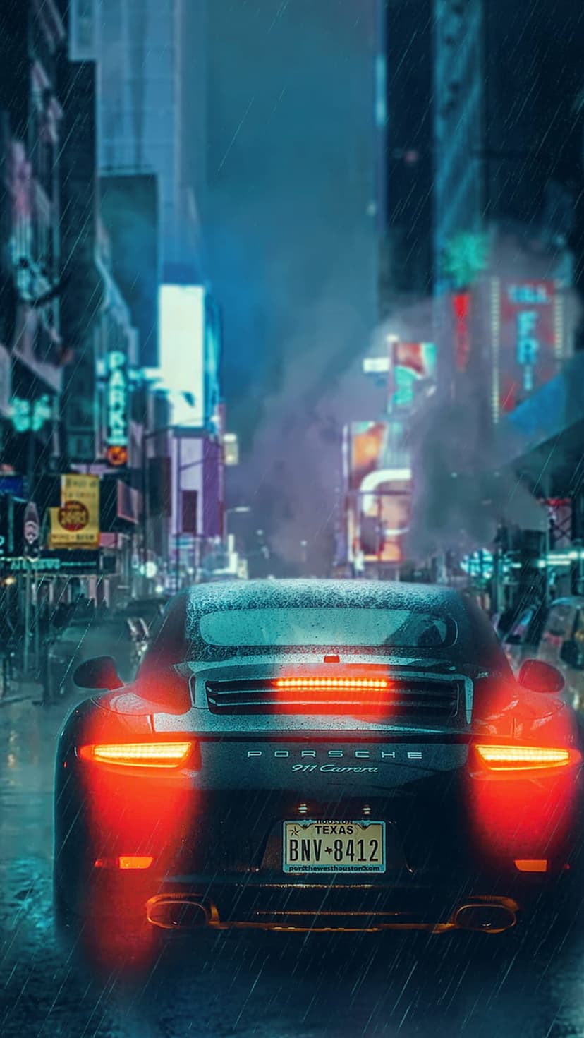 Porsche 911 Carrera with glowing taillights drives through a rainy city street lined with neon signs at night.
