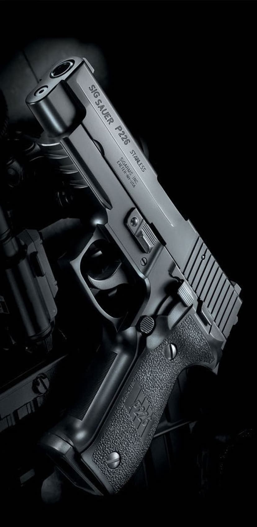 SIG Sauer P226 Stainless pistol highlights metal slide serrations and textured grip logo in low light.