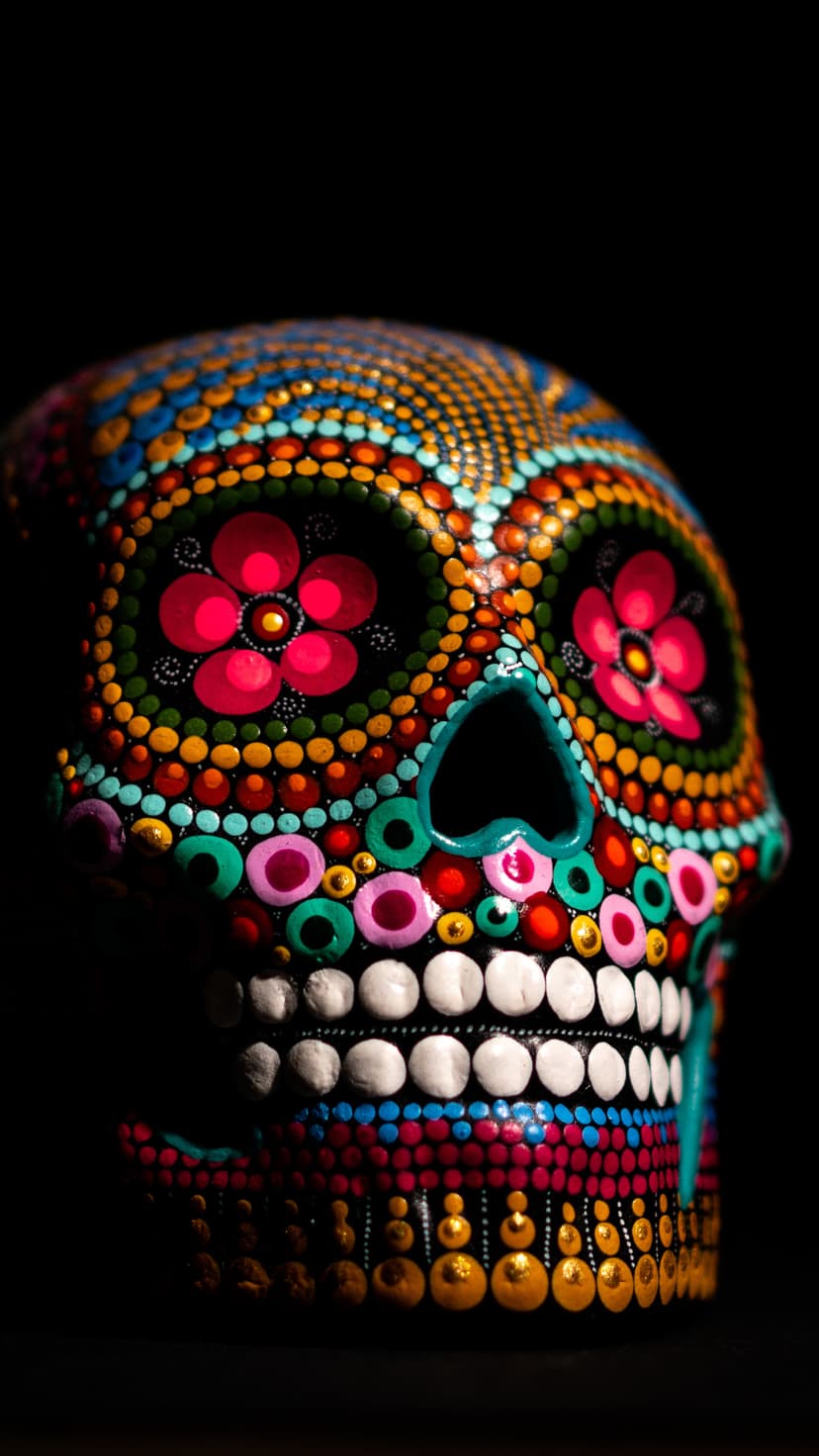 Sugar skull decorated with multicolored dots and floral patterns against a dark, contrasting background.