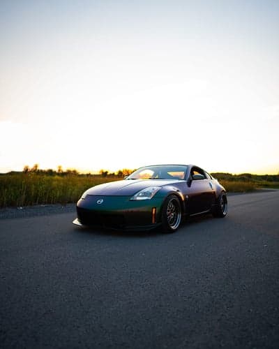Iridescent Nissan 350z parked on rural road at sunset