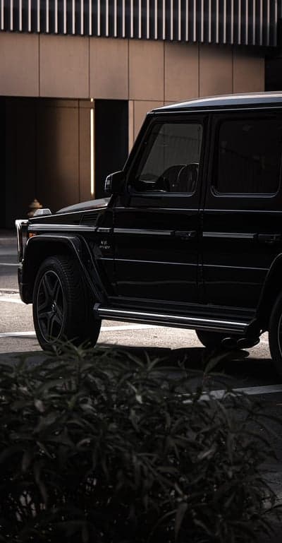 Black Mercedes-Benz G-Wagon parked near modern building
