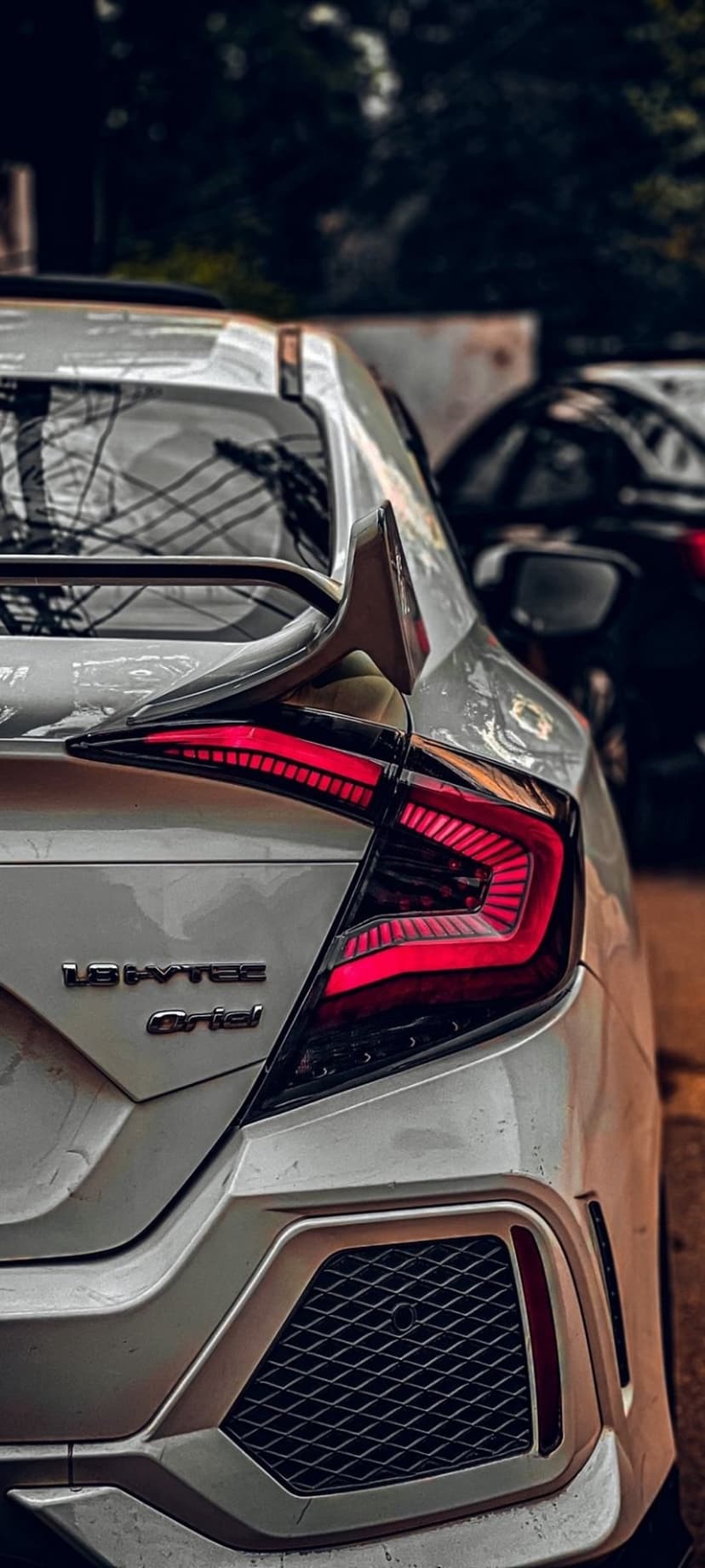 White Honda Civic rear view showcasing C-shaped LED taillights, a sporty spoiler, and 1.5 VTEC Turbo badging.