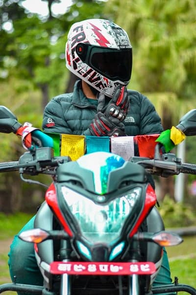 Motorcyclist in Decorative Helmet and Prayer Flags