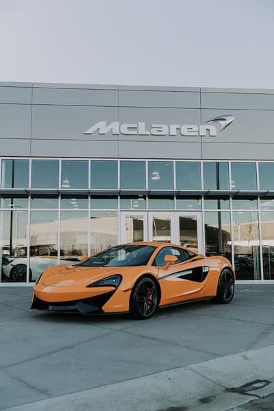 Orange McLaren 570S parked at dealership showroom