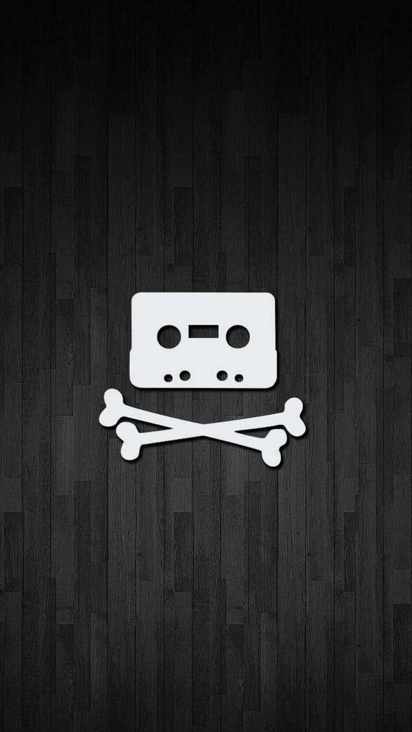 White cassette tape arranged over crossed bones centered on a textured vertical dark wood grain background.