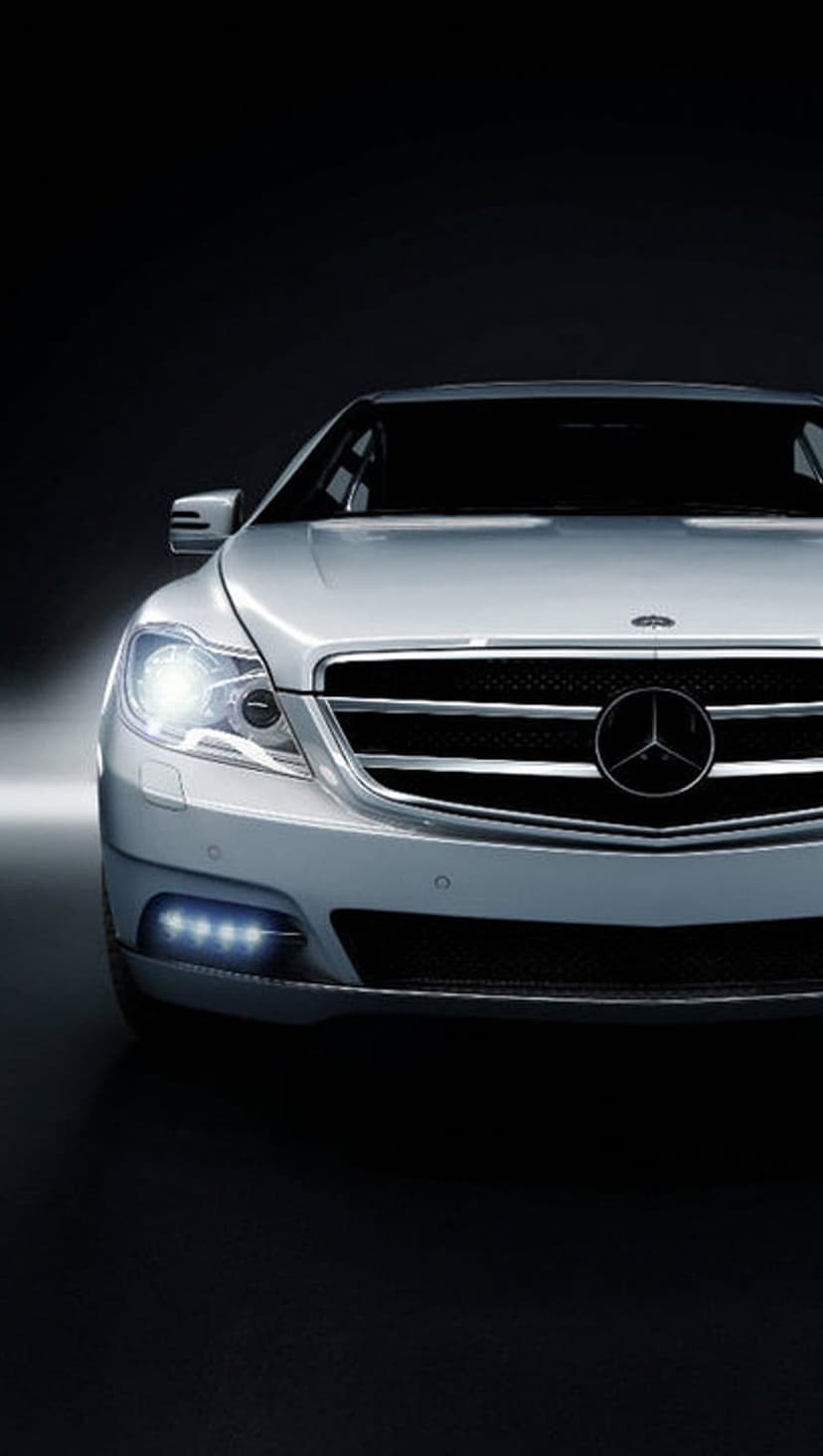 Mercedes-Benz silver sedan front grille featuring illuminated LED headlights and a central star logo.
