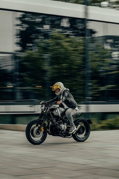 Urban Biker in Motion with Gold Visor Helmet Phone Wallpaper