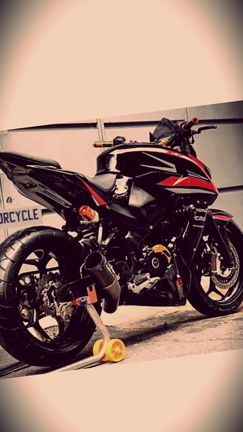Black and red sportbike on a yellow paddock stand against a grey wall shows sleek racing lines and custom exhaust.
