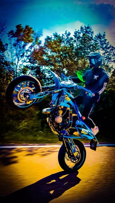 Motorcyclist Performing Wheelie on Blue Bike