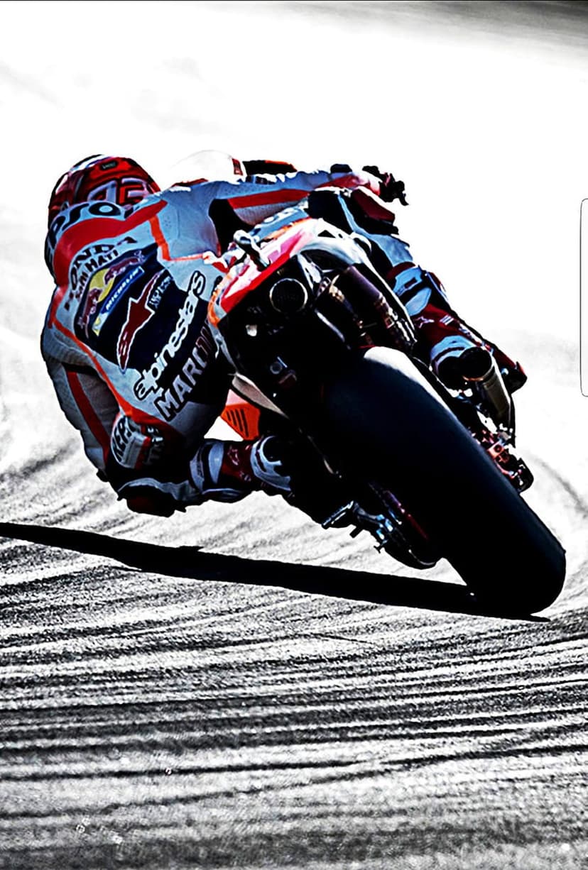 MotoGP racer in a leather suit leans a colorful motorcycle deep into a turn on a textured asphalt race track.