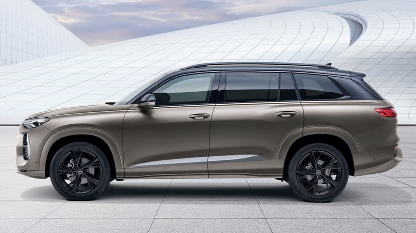 Side profile of a metallic bronze Audi SUV with black rims parked before curved white futuristic architecture.