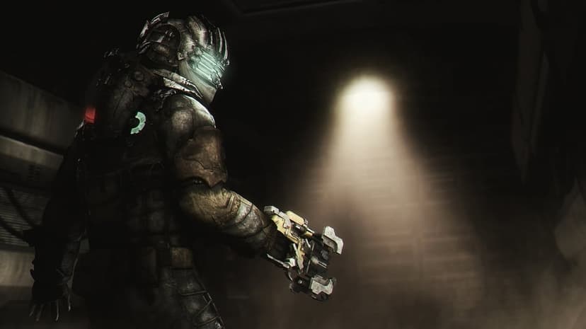 Isaac Clarke in metal armor holds a plasma cutter in a dark industrial corridor lit by a single moody spotlight.
