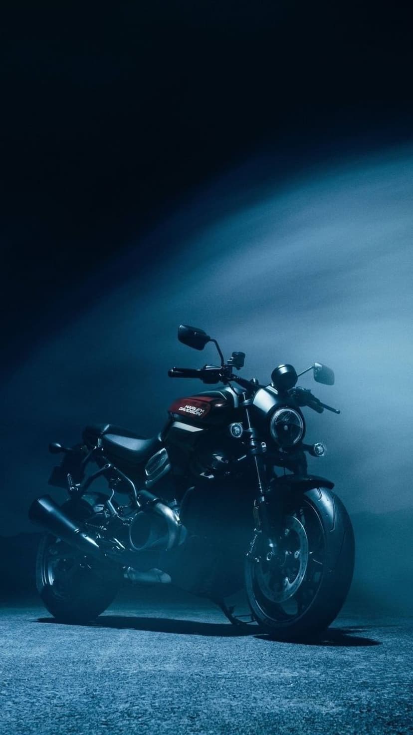 Harley-Davidson Nightster cruiser with red details surrounded by blue mist and moody atmospheric lighting.