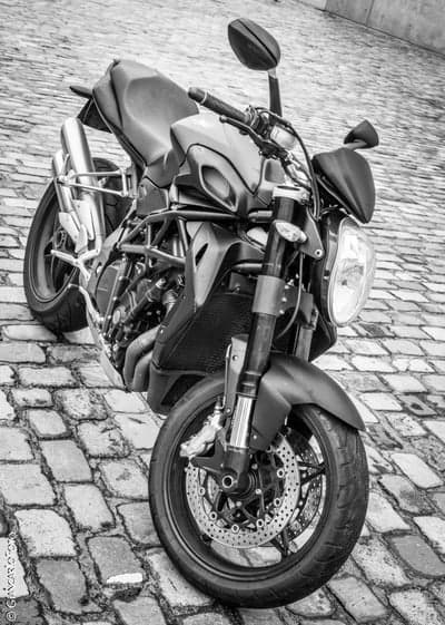 Urban Noir Motorcycle on Textured Cobblestone Wallpaper
