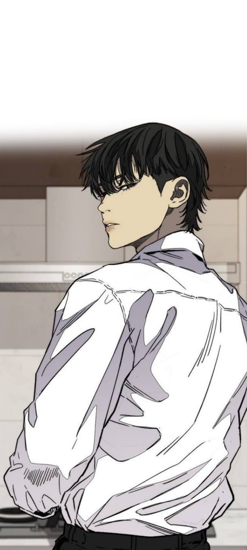 Black-haired man in a white collared shirt looking over his shoulder against a blurred minimalist kitchen background.