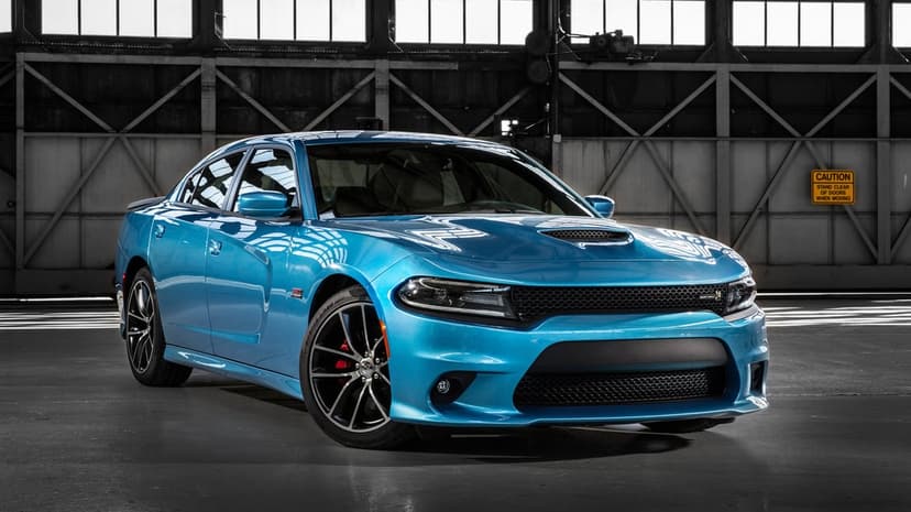 Metallic blue Dodge Charger SRT Scat Pack parked in a warehouse with large windows and red brake calipers.