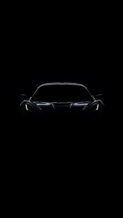 Dark Silhouette of a Sports Car with Glowing Headlights