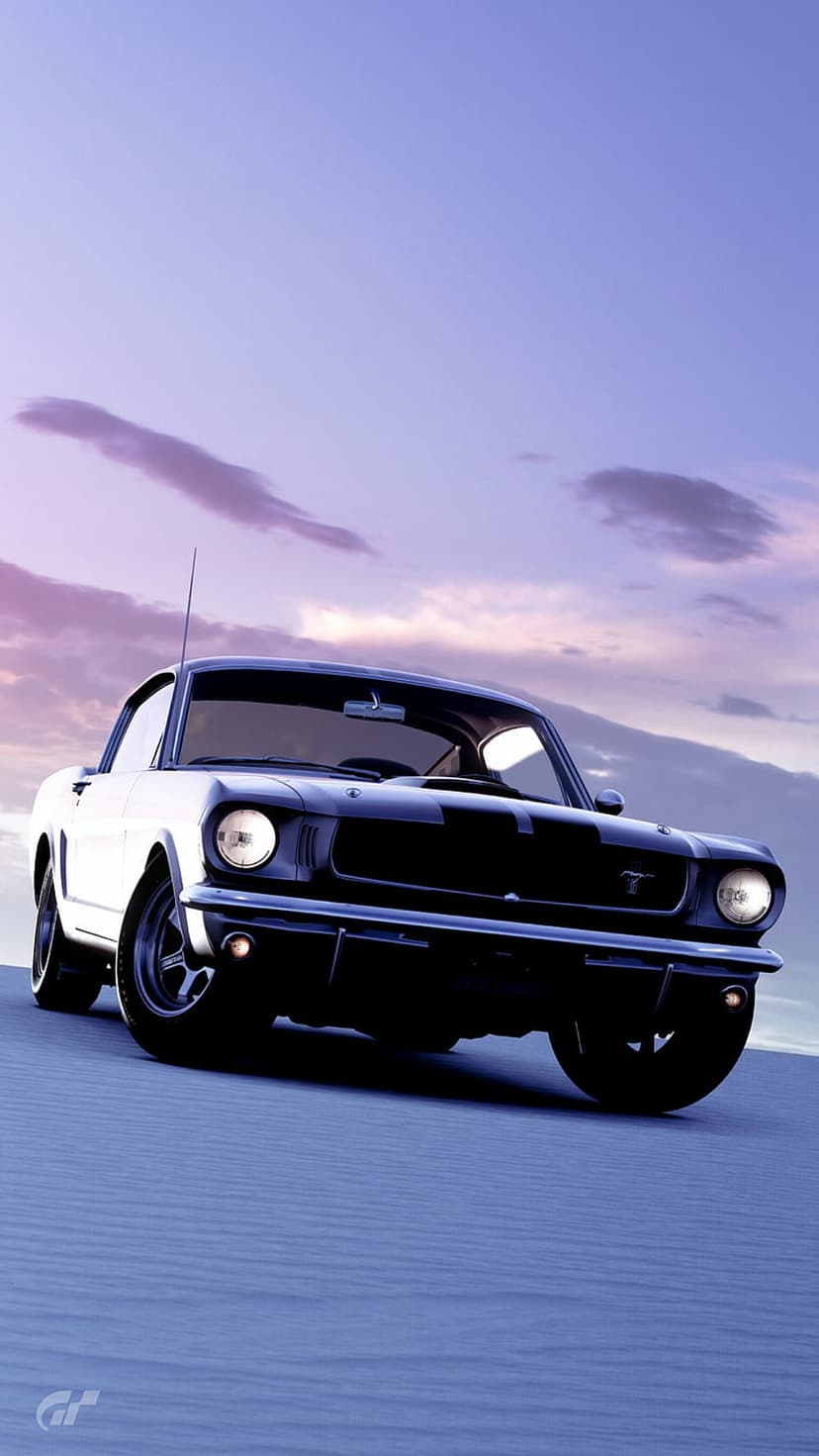 Black Ford Mustang with glowing headlights parked on desert sand dunes under a purple and pink sunset sky.