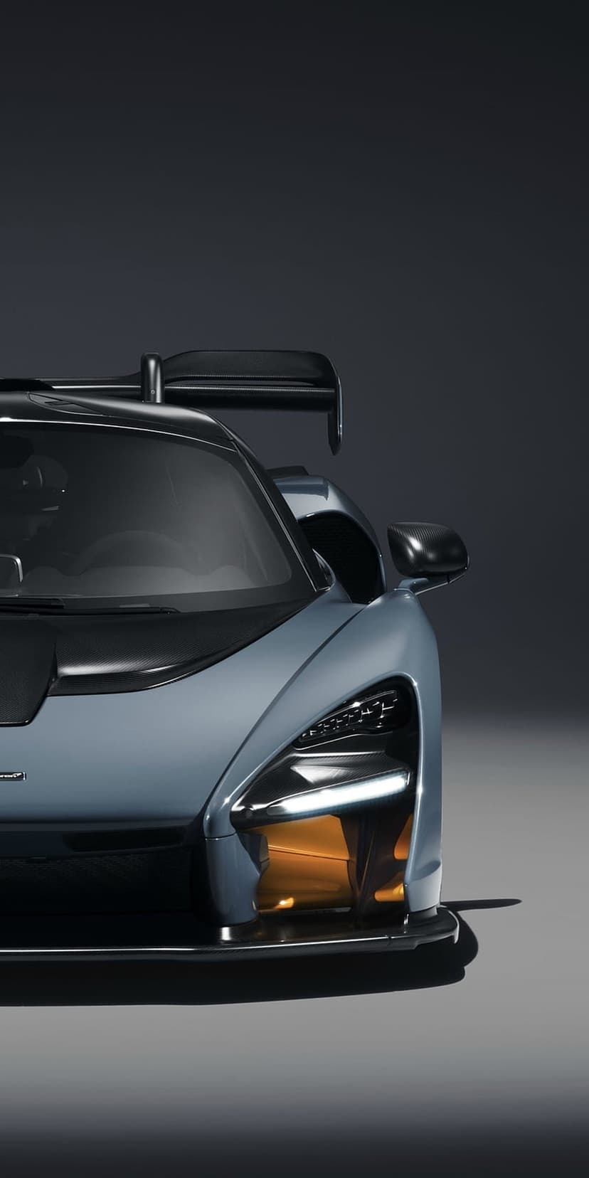 McLaren Senna front view with light blue paint, orange LED accents, and aggressive aerodynamic hood vents.