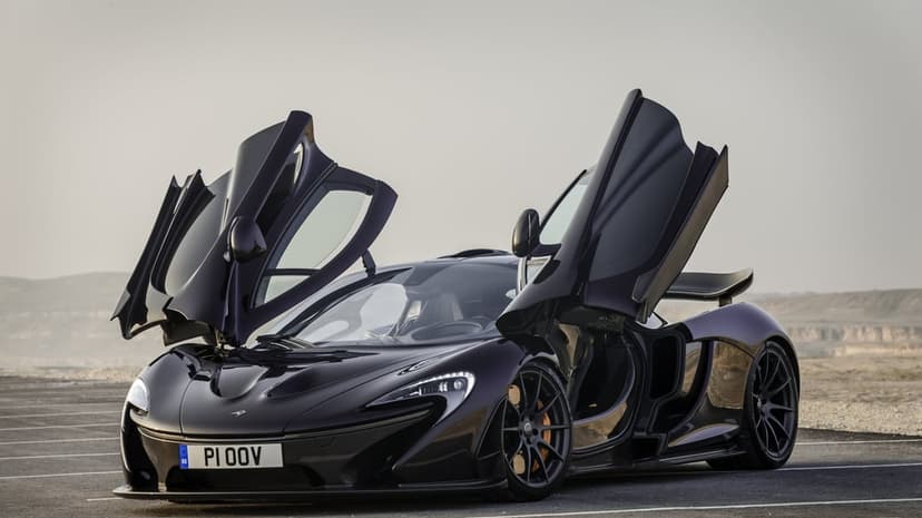 McLaren P1 hypercar in deep purple with dihedral doors open on an asphalt road under a gray sky.