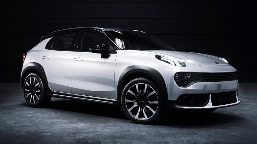 White modern compact SUV with black roof and multi-spoke wheels in a dark studio with dramatic lighting.
