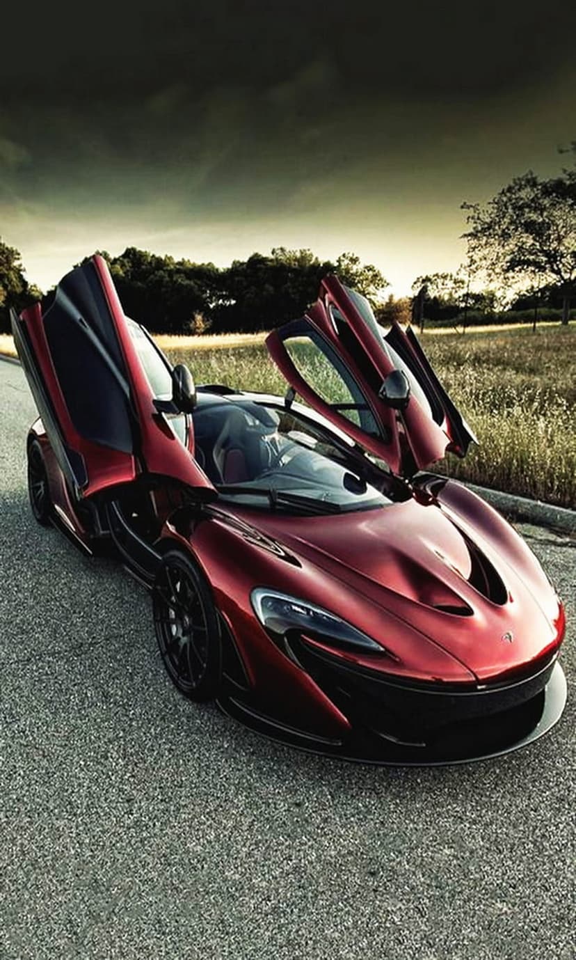 McLaren P1 supercar with red paint and open dihedral doors sits on an asphalt road under a cloudy gray sky.