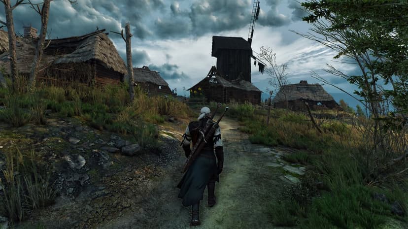 Geralt of Rivia walks through a rustic village with thatched huts and a tall windmill under a cloudy stormy sky.