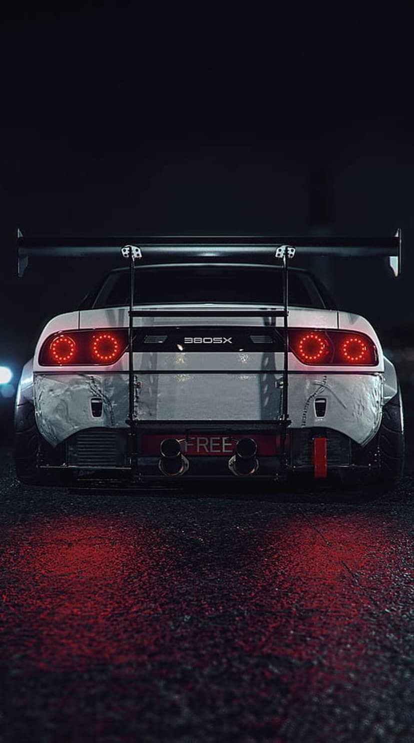 Nissan 300SX with widebody kit and rear wing parked on wet night street with red glowing circular taillights.